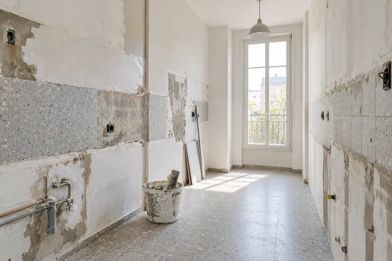 Visualización conceptual IA: Cocina sin muebles con paredes en preparación y zonas de enlucido.